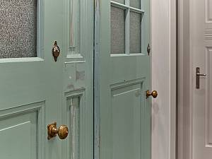 Türen einer Umkleide eines Jugendstilbads umgearbeitet zu einem Einbauschrank für Wäsche.