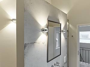 Kinderbad mit freistehender Wandscheibe, hinter der sich Dusche und WC verstecken, Occhio Leuchten.