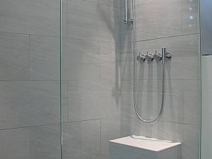 Barrierefreies Bad mit Sitzmöglichkeit im Duschbereich, Vola Armaturen.