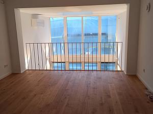 Blick von der Galerie in den 2-geschossigen Wohnraum, Wandleuchten Occhio. 