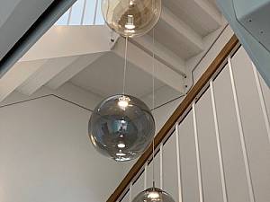 Pendelleuchten über 3 Geschosse im Treppenauge abgehängt, Globe Glas Lichtobjekt P ( Sonderanfertigung ).