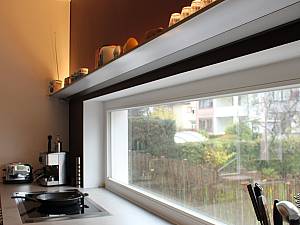 Kunstlicht als indirekte Beleuchtung über farbige Wandfläche, natürliches Licht über horizontales Fenster als Arbeitsflächenbeleuchtung.