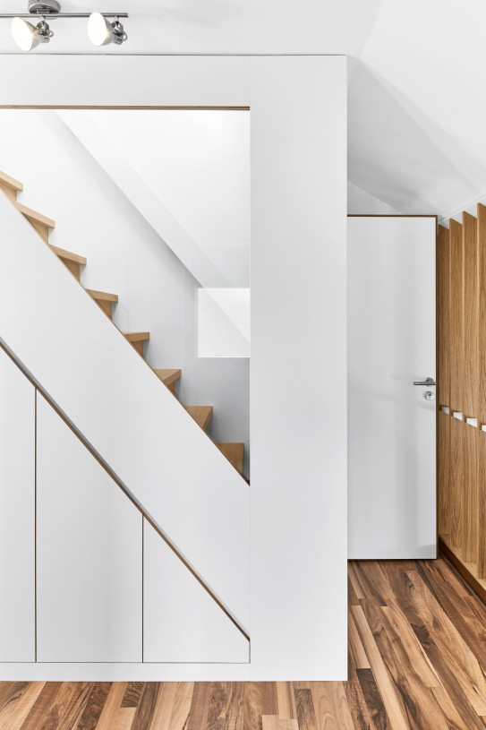 Treppenmöbel mit Einbauschrank und Dreiecksfenster zur Belichtung des innenliegenden Flurs.