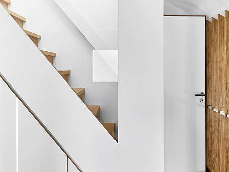 Treppenmöbel mit Einbauschrank und Dreiecksfenster zur Belichtung des innenliegenden Flurs.