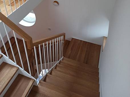 Stahlwangentreppe als 3-läufige Podesttreppe mit großem Treppenauge, Stabstahlgeländer, Trittstufen Eiche geölt.