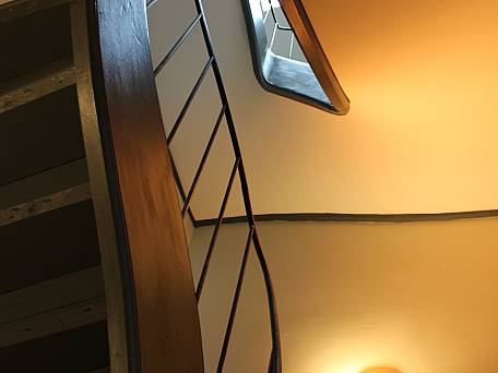 Historische, gewendelte Holztreppe, neue  Belichtung über ein Dachflächenfenster in das Treppenauge bis zum Erdgeschoß.